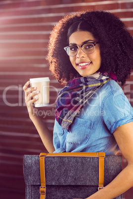 Smiling attractive hipster with felt bag and coffee