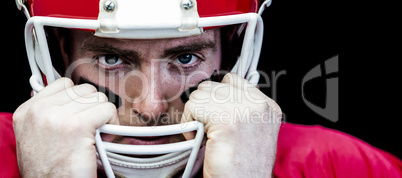 Portrait of american football player holding onto his helmet