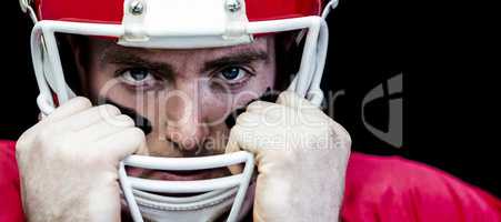 Portrait of american football player holding onto his helmet