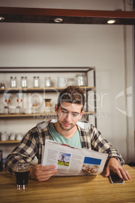 Hipster having coffee and reading newspaper