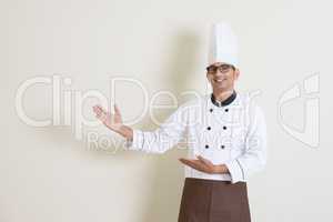 Indian male chef in uniform showing something