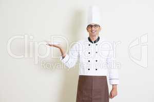 Indian male chef in uniform holding a plate