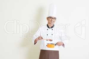 Indian male chef in uniform cooking