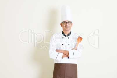 Indian male chef in uniform holding spatula