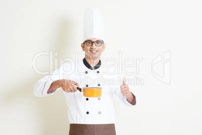 Indian male chef in uniform cooking and thumb up