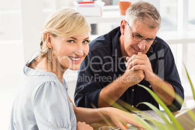 Smiling business team working on laptop