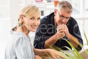 Smiling business team working on laptop