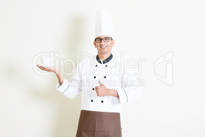 Indian male chef in uniform presenting a coffee cup and thumb up