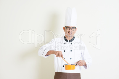 Indian male chef in uniform cooking food