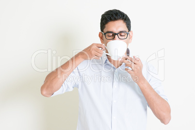 Casual business Indian male drinks coffee