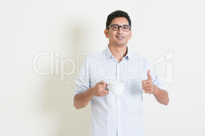 Casual business Indian male drinking coffee and thumb up