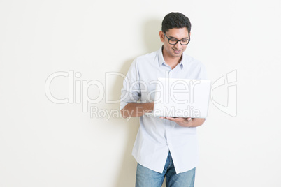 Casual business Indian man using laptop