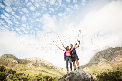 Young happy joggers standing on rock cheering