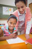 Pupil and teacher at desk in classroom