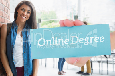 Online degree against pretty student smiling at camera with clas