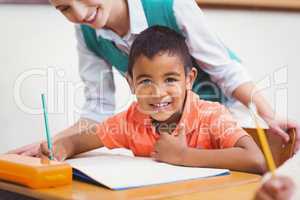 Teacher helping a little boy during class