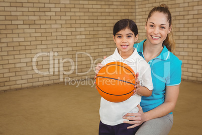 Student holding basketball with teacher