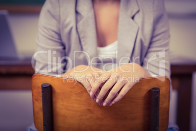 Teacher sitting on chair in a classroom