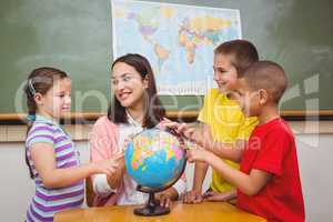 Students pointing to places on a globe