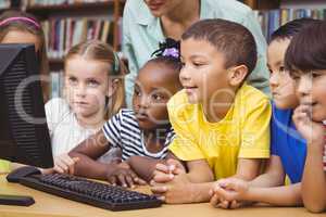 Pupils and teacher in the library using computer