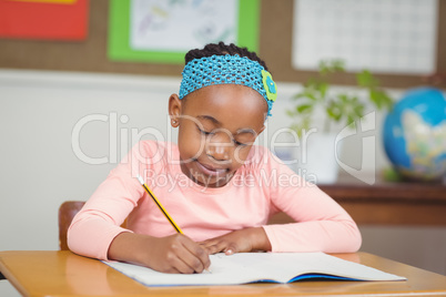 Focused pupil working at her desk in a classroom