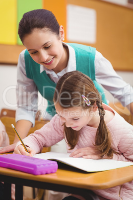 Teacher helping a little girl during class