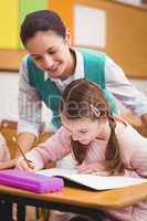 Teacher helping a little girl during class