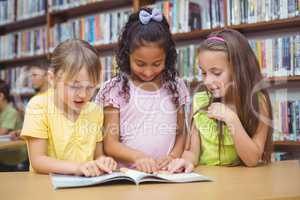 Pupils reading book together in library