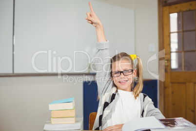 Cute pupil raising hand in a classroom