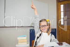 Cute pupil raising hand in a classroom