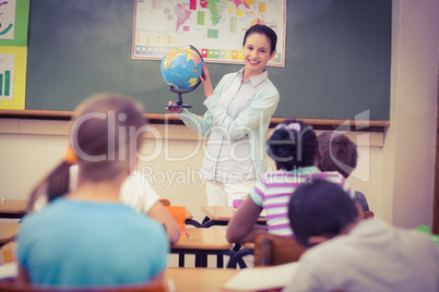 Pupils listening to their teacher holding globe