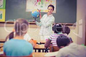 Pupils listening to their teacher holding globe