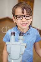 Pupil looking through microscope in class