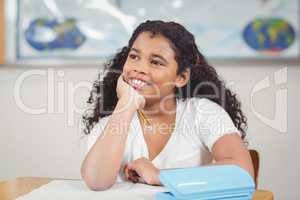 Cute pupil daydreaming in a classroom