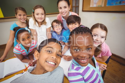 Teacher and pupils working at desk together