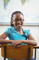 Cute pupil sitting at her desk in a classroom