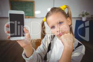 Cute pupil showing smartphone to camera