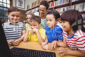 Pupils and teacher in the library using computer