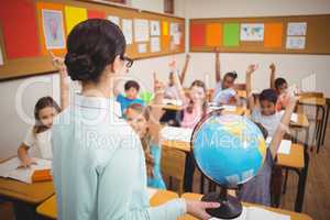 Teacher showing pupils a globe