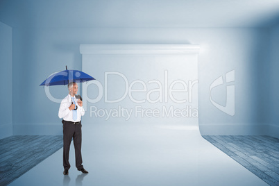 Composite image of happy businessman holding umbrella