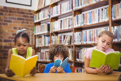 Happy pupils reading a library book