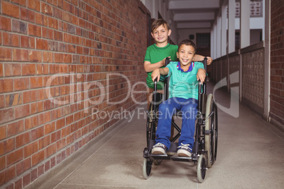 Smiling student in a wheelchair and friend beside him