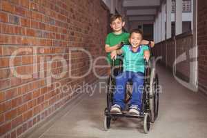 Smiling student in a wheelchair and friend beside him