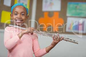 Cute pupil with flute in a classroom