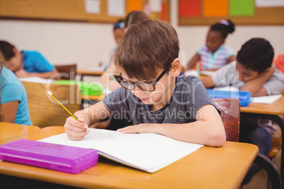 Little boy working at his desk in class