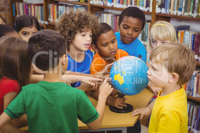 Students pointing at a globe