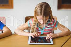 Cute pupil in class using tablet pc