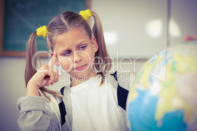 Concentrated pupil looking at globe in a classroom