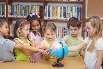 Pupils in library pointing to globe