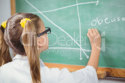 Pupil with lab coat writing on chalkboard in a classroom
